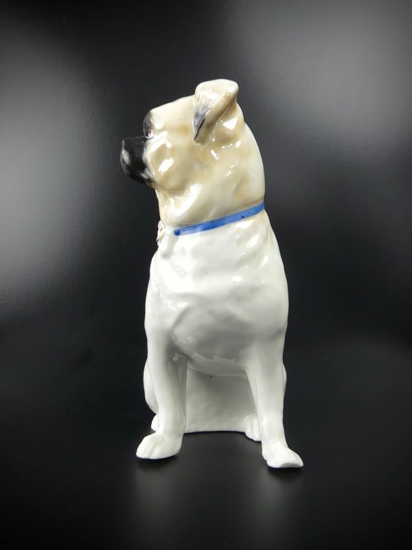 Carlin en porcelaine chien assis au collier bleu et nœud doré (profil)