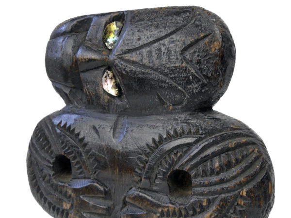 Teko Teko Maori plat sculpté en bois brun foncé et ormeaux (détail)