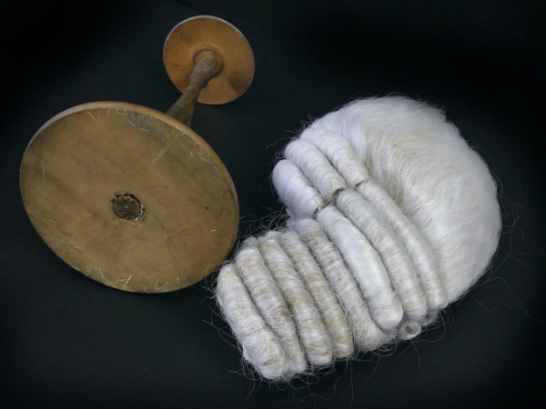 Perruque blanche sur porte perruque ancien en bois tourné brun (détail)