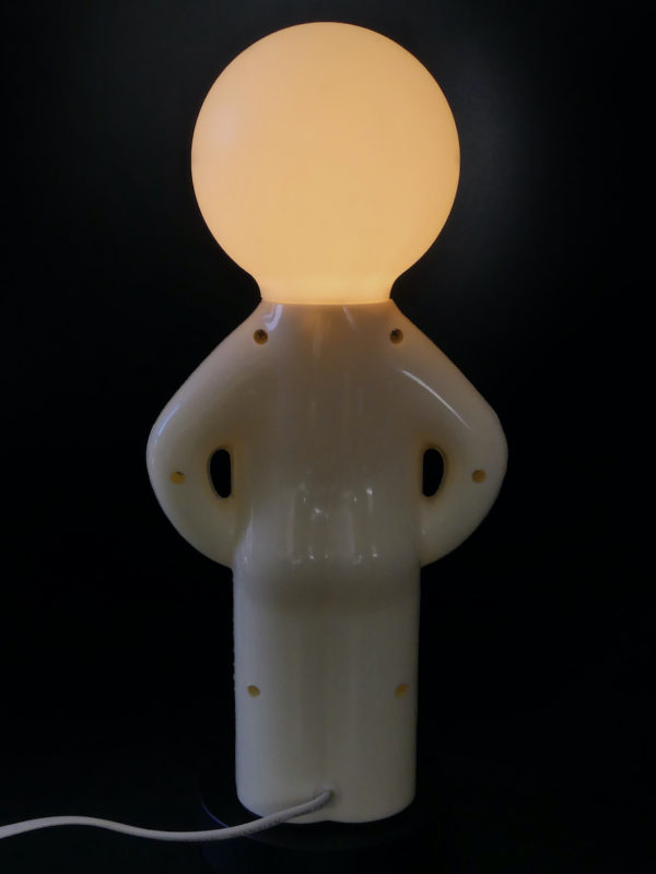 Lampe Mr. P blanche présentée sur socle rond (dos allumée)