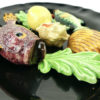 Petit plat ovale Vallauris barbotine noire poissons et coquillages Années 60 (détail)
