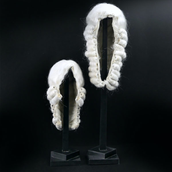 Perruques blanches longue et courte sur porte perruque en bois noir (face)