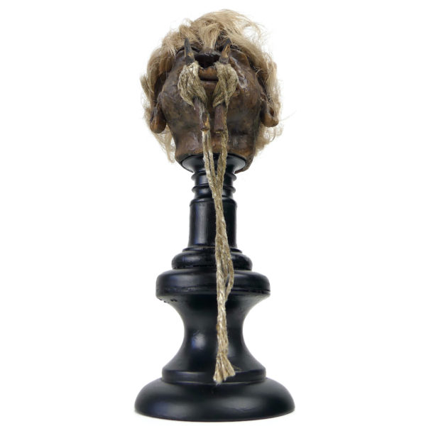 Tête réduite Tsantsa Jivaro réplique sur pied en bois tourné noir (dessous face)