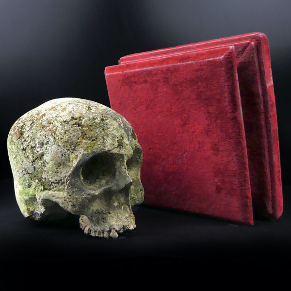 Crâne en pierre sculptée sur piédestal en velours rouge Vanité Memento mori (détail)